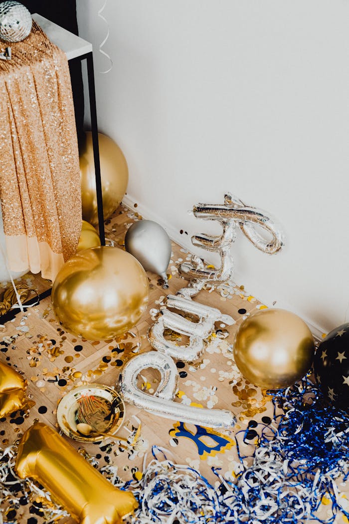 Festive gold and silver balloons with confetti creating a celebratory New Years Eve atmosphere.